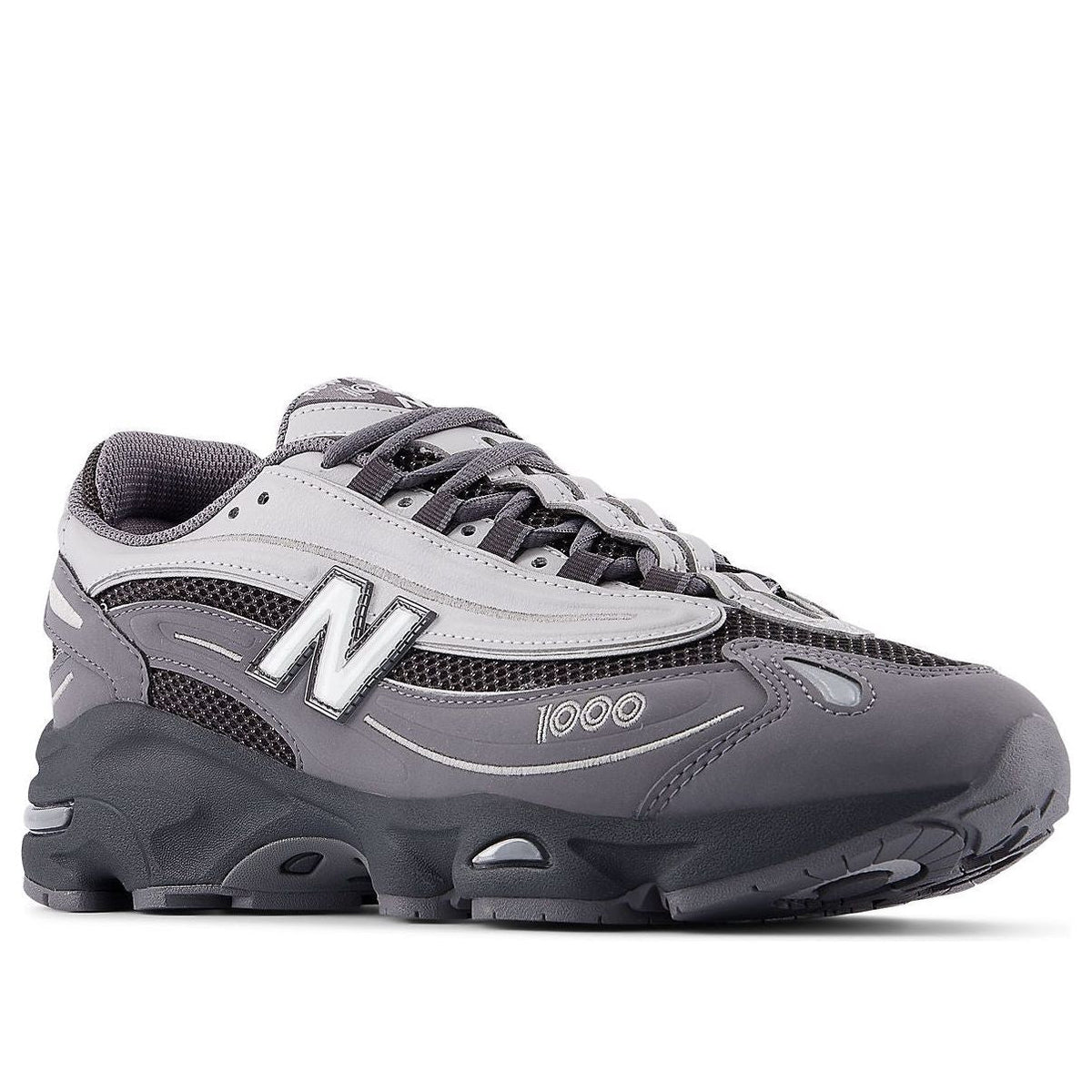 New Balance 1000 Castlerock, driekwart aanzicht toont grijs-zwarte colorway met mesh inserts en contrast stiksels