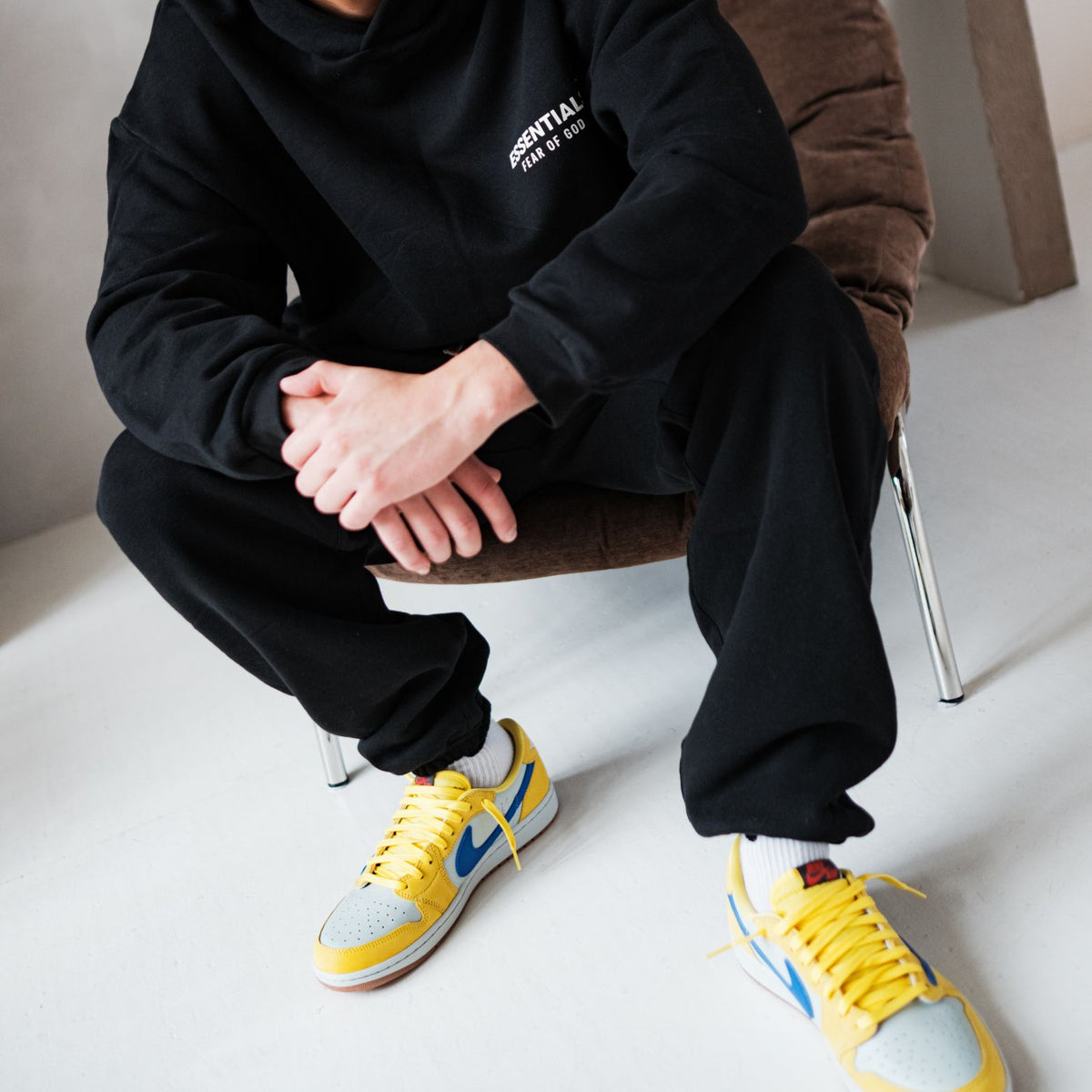 Fear of God Essentials FW24 Black White Full set, gedragen detail met joggingbroek en gele sneakers