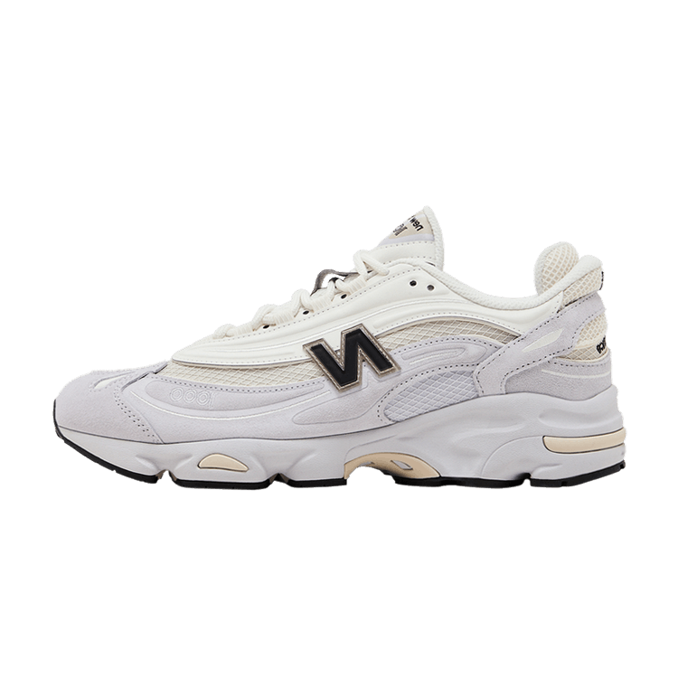 New Balance 1000 Pearl Grey Black, zijaanzicht van witte sneaker met grijze en beige accenten, zwart N-logo en zwarte zool