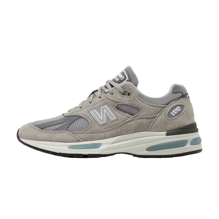 New Balance 991v2 MiUK Rock Ridge Grey, zijaanzicht met grijze suède, mesh details en witte zool met blauwe accenten