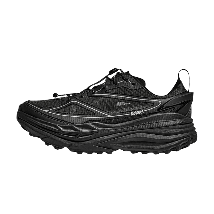 Hoka One One Stinson One7 Black Silver, zijaanzicht met zwart mesh en zilveren details op dikke zool