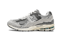 New Balance 2002R Protection Pack Rain Cloud, zijaanzicht met grijze suède, zwarte panelen en roomkleurige zool