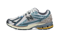 New Balance 1906R Metallic Teal zijaanzicht met witte en turquoise mesh, donkerblauwe stiksels en gele zool
